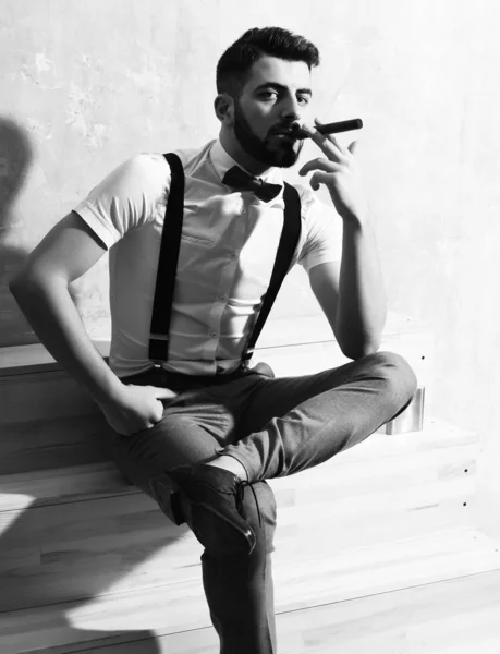 Бородатий чоловік сидить на дерев'яних сходах з серйозним обличчям — стокове фото