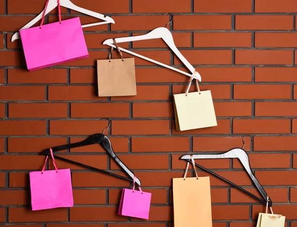 Colgadores y bolsas de compras sobre fondo de pared de ladrillo — Foto de Stock