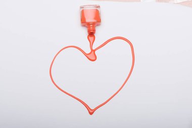 Beyaz arka plan üzerinde tırnak cilası ile boyalı turuncu kalp