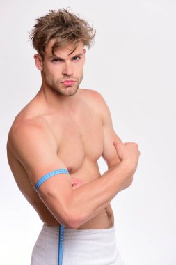 Havlu ve esnek cetveli olan adam beyaz arka planda izole edilmiş.