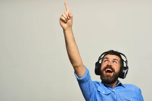 Chico con barba y cara excitada escucha música —  Fotos de Stock