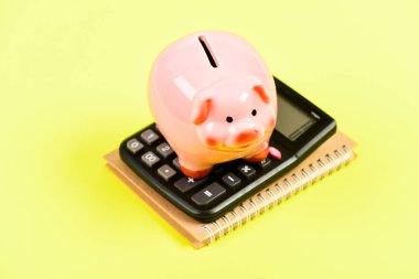 Vergi hesap makinesi. Muhasebe işi. Kumbaranın para tasarrufu sembolü. Yatırım konsepti. Domuz kumbarası ve hesap makinesi. Vergiler ve ücretler değişebilir. Akıllı finansal seçimler yapmaya yardım etmek. Vergileri öde
