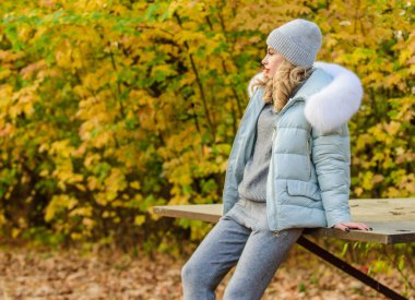 Sıcak örgü. Pratik ve konforu hisset. Kadınlar parkta sonbahar sezonunun tadını çıkarırlar. Dinlenmek için giysiler. Doğada rahatlayan, örgü elbise ve ceket giyen bir kız. Model örgü giysileri arka planda kalır