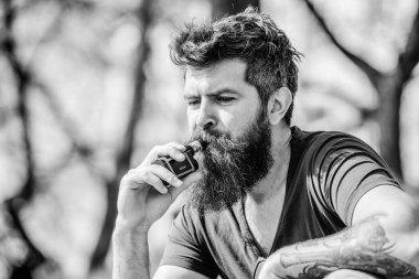 Sağlık güvenliği ve bağımlılık. Buhar soluyarak. Elektronik sigara içen vahşi erkek sakallı. Hipster adam buhar makinesi tutuyor. Elektronik sigara içen bir adam. Sakallı, olgun bir hippi. Bayım. Uzman