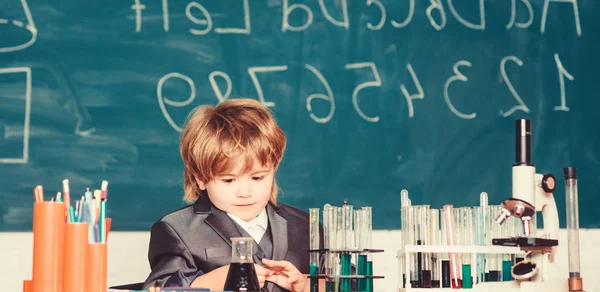 Un niño pequeño estudia química. niño pequeño usando microscopio en la clase de la escuela. resultado. Concepto médico. Pequeño niño genio. tubos de ensayo con líquido para la investigación. aprender para el futuro. Inspirado para trabajar duro — Foto de Stock