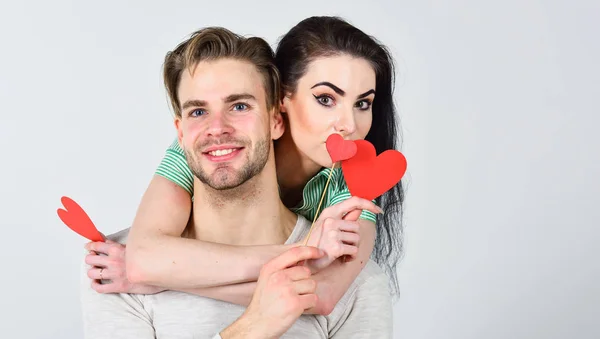 Hombre y chica guapa enamorados. Día de San Valentín y amor. Las ideas románticas celebran el día de San Valentín. Concepto de San Valentín. Hombre y mujer pareja en el amor abrazo y mantener el corazón rojo tarjetas de San Valentín de cerca — Foto de Stock