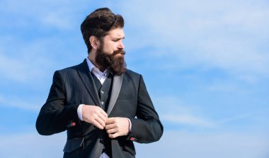 Moda modası. Erkek sakalı ve bıyığı resmi kıyafetler giyer. Çok doğru. İş adamı sakallı, gökyüzü geçmişi olan. Kusursuz kıyafet. Erkek takım elbisesi ceketi ayarlıyor. Erkek moda resmi erkek giyim.