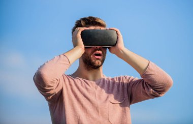 Gelecek şu andır. Kendi işini kur. Dijital gelecek ve yenilik. Seksi adam gökyüzü arkaplan gözlüğü. Maço adam kablosuz sanal gerçeklik gözlüğü takıyor. VR kulaklığı kullan. adam sanal gerçeklik gözlükleri