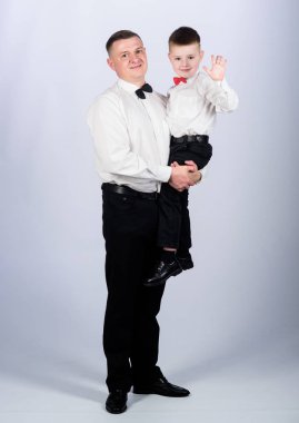 Baba ve oğulun akrabaları. Centilmen yetiştirilme. Baba kucağında oğul resmi kıyafet taşıyor. Büyü artık, beyefendi. Centilmen yetiştirilme. Küçük oğlu, soylu bir babanın izinden gidiyor. Aile tatili