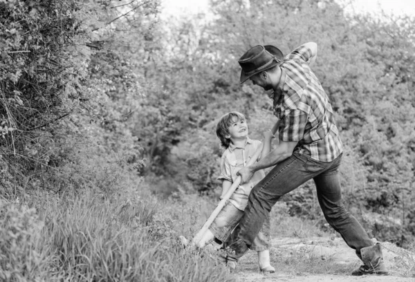 Lycklig barndom. Äventyrs jakt för skatter. Liten hjälpare i trädgården. Söt barn i naturen ha kul med cowboy pappa. Hitta skatter. Liten pojke och far med spade söker skatter — Stockfoto