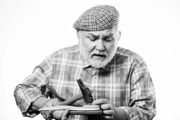 Man bearded handyman working with tools white background. Custom made shoes. Shoe repair shop. Senior master with hammer repairing shoe. Handmade concept. Designing shoe. Craftsman laborer worker