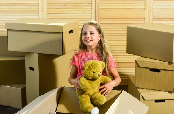 All Within Your Reach. happy little girl with toy. purchase of new habitation. Cardboard boxes - moving to new house. happy child cardboard box. Moving concept. new apartment — ストック写真