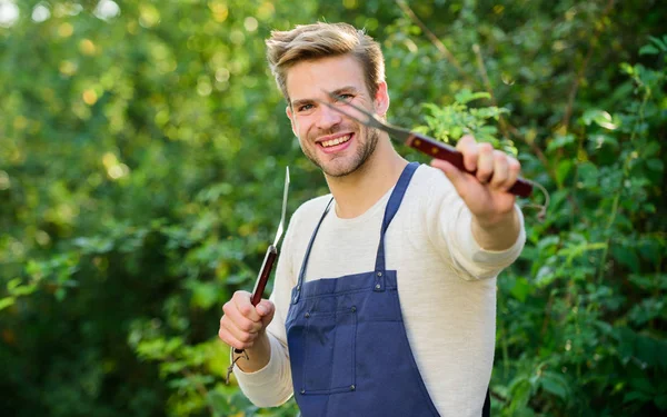 Herramientas para asar carne al aire libre. Fiesta de barbacoa. Cocinar hamburguesas. Concepto de picnic. Chef Bbq. Un chico guapo cocinando comida. El hombre tiene equipo de barbacoa. Asar comida. Utensilios de barbacoa. Fin de semana — Foto de Stock