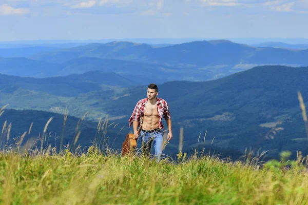 A zene ereje. szexi férfi kockás inges gitárral. hipszter divat. Nyugati kempingezés és túrázás. Boldog és szabad. Cowboy férfi csupasz izmos felsőtesttel. akusztikus gitáros. country zene dal — Stock Fotó