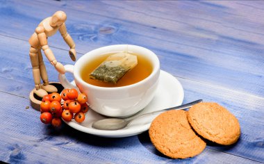 Kafe menüsü. Böğürtlen çayı. Seramik fincan sıcak demlenmiş çay içeceği. Sağlık hizmetleri kocakarı ilaçları. Aromatik rowanberry içeceği için. Mavi arka planda bir fincan çay yakın plan. Gurme lezzetli tat.