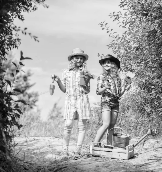 Gyönyörű virágárus a munkahelyén. ökológia és környezetvédelem. Földi nap. nyári családi farm. A gyerekek kertészeti eszközöket tartanak. gazdálkodás és mezőgazdaság. Tavaszi vidék. lányok farmer a faluban — Stock Fotó