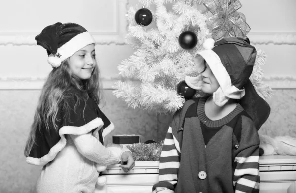 Wintermaskerade-Konzept. Frohe Weihnachten. Familientraditionen. Kinder feiern fröhlich Weihnachten. Geschwister feiern Weihnachten oder treffen sich zu Neujahr. Kinder Weihnachtskostüme Weihnachtsmann und Elfe — Stockfoto