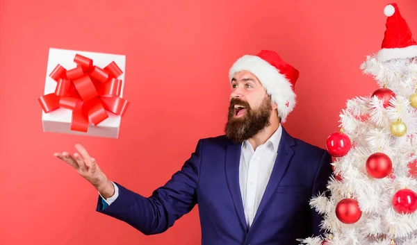 Gyors ajándékszállítás. Ajándék doboz ünnepi szalaggal íj esik jobbra a férfi kezét. Ajándék szolgáltatás koncepció. Küldj vagy fogadj karácsonyi ajándékot. Férfi szakállas hipster formális öltöny boldog ünneplik karácsony — Stock Fotó