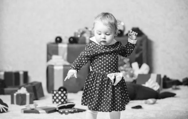 Вещи, связанные с малышами на Рождество. Маленькая девочка играет рядом с кучей подарочных коробок. Семейный праздник. Рождественские мероприятия для малышей. Рождественское чудо. Подарки для первого ребенка — стоковое фото