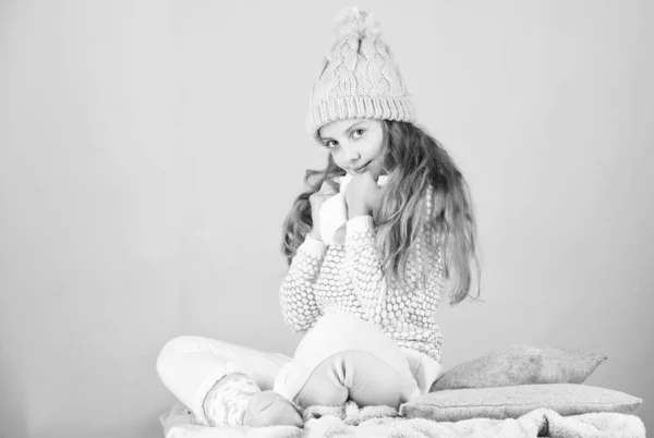 Niña desgaste de punto cálido sombrero relajante fondo rosa. Moda de invierno concepto de ropa de abrigo. Accesorios cálidos que te mantendrán acogedor invierno. Niño pelo largo sombrero de lana caliente disfrutar de calor y suavidad — Foto de Stock