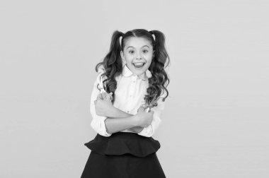 Çocuk deli gibi kesilmeye hazır. Sarı arka planda elinde makas tutan mutlu küçük çocuk. Resmi okul üniformasıyla gülümseyen küçük bir çocuk. Sanat derslerinde öğrenen neşeli kadın çocuk.