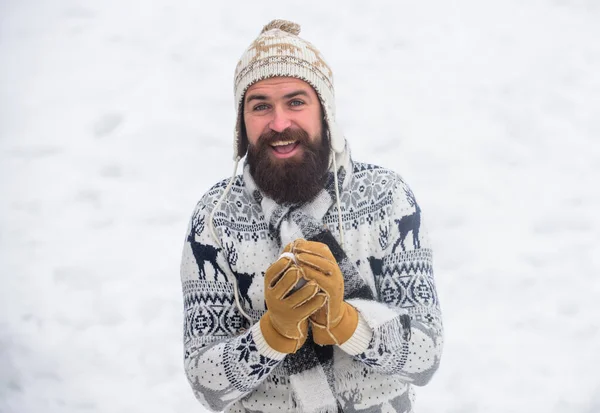 Glada skäggiga hipster stickad hatt och varma handskar leka med snö utomhus. Julhelgen. Göra snöboll. Lycka koncept. Leende man snö bakgrund. Snö spel. Ha en rolig vinterdag — Stockfoto