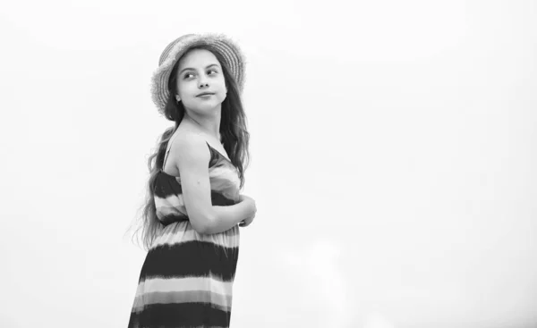 Modelo linda dama. Feliz día de los niños. niño despreocupado en vestido de verano. niña pequeña con el pelo rizado largo. felicidad infantil. moda de verano para niños. chica pequeña pasar tiempo al aire libre. tiempo nublado — Foto de Stock