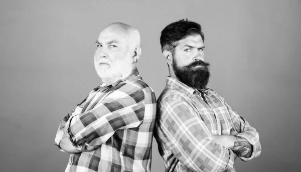 competition. youth vs old age compare. retirement. father and son family. generational conflict. male beard care. checkered fashion. barbershop and hairdresser salon. two bearded men senior and mature