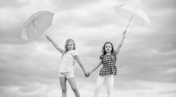 Follow me. school time. autumn season. rainy weather forecast. fall kid fashion. Feeling protected at this autumn day. happy small girls with umbrella. positive and bright mood. best friends