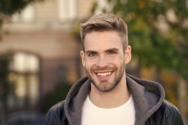 Mükemmel gülümseme. Yakışıklı bir erkek portresi. Yüz kılı ve cilt bakımı konsepti. Yakışıklı bir yüz. Yakışıklı, tıraşsız bir yüz ve şık saçlar. Beyaz adam şehir geçmişi var. Sıradan görünümlü sakallı adam.