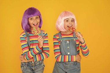 Yapay saç stilleri olan çocuklar lolipop yiyor. Anime kongresi. Canlı karakterler fantastik temalar. Modern çocukluk. Çocuk bayramı. Anime cosplay parti konsepti. Mutlu küçük kızlar. Anime fan
