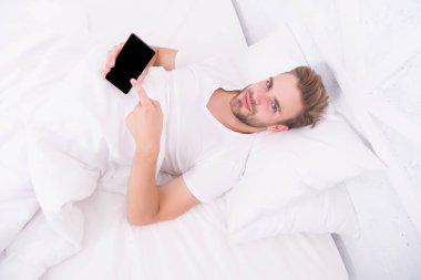 Uygulama, uyku evrelerini analiz eder ve sizi en uygun zamanda uyandırır. Uykuyu takip eden uygulamalar. Adam yatakta cep telefonu kullanıyor. Uyanıyorum. Daha derin uyku analizi yap. Sabah alarmını kur.