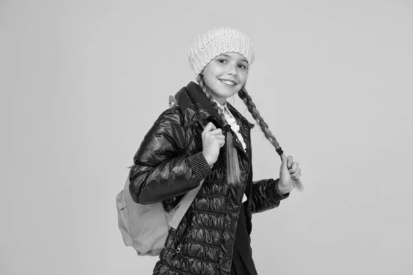 Adorable alumno. Otoño otoño invierno. Niño con mochila. Tienda de moda. Concepto de moda. Chica usar sombrero de punto y chaqueta de fondo amarillo. Compra ropa para la temporada escolar. Traje de moda colegiala — Foto de Stock