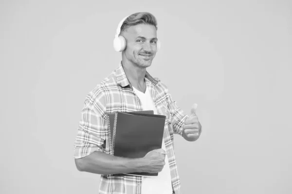 Outra forma de estudar. Aprender inglês. Tecnologia educacional. Estuda. Conceito de livro áudio. Acesso mundial ao conhecimento. Biblioteca de áudio. Homem bonito estudante universitário fones de ouvido livros. Línguas de estudo — Fotografia de Stock