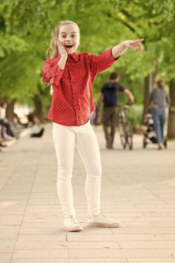 Doğada çocukluk oyunu ve eğlence. Mutlu küçük çocuk parkta oynamak için rahat giysiler bir yere işaret. Yaz gününde çocukluk etkinlikleri. Çocukluk ve büyüyen. Mutlu çocukluk