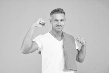 Yakışıklı ve kaslı. Mavi arka planda havlusu olan yakışıklı adam. Kolu kaslı, kaslı bir sporcu. Tıraşsız yakışıklı yüzlü ve şık sarı saçlı bir erkek. Yakışıklı ve çekici.