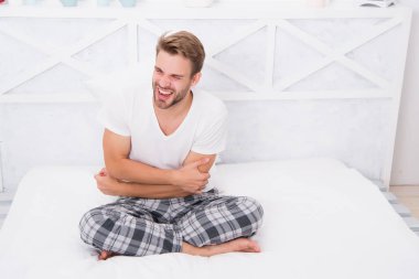 Uyurken elimi uzat. Zor bir sabah uyanıyor. Acı ve stres hisset. Uyumak için daha fazla zamana ihtiyacım var. Erkekler için pijama. Rahat ol. Erkek uykulu hissediyor. Stresli adam pijamayla oturur. Adam yatakta dinleniyor.