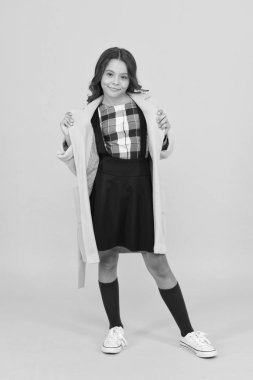 Gittiği her yerde şık görünüyor. Şık sonbahar görünüşlü mutlu bir kız. Sarı arka planda şık bir okul çocuğu gülümsemesi. Moda tarzında küçük bir çocuk. Modaya uygun ve resmi