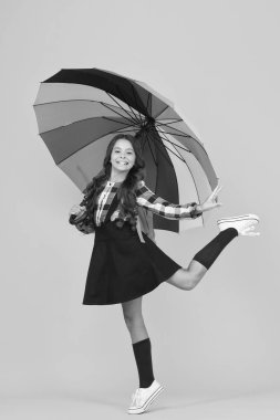 - Okula gidiyorum. Neşeli gülümseyen liseli kız. Yağmurlu gün eğlencesi. Şemsiye altında iyi yürüyüşler. Yağmur konseptinin tadını çıkar Çocuk mutlu bir şekilde renkli gökkuşağı şemsiyesi tutuyor. Uygun giysilerle yağmurlu hava