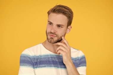 Penisli surat. Çözüm bulun. Sarı arka planda düşünceli bir adam. Hipster sakallı yüzü bir şeyde emin değil. Zor bir soru. Adam ciddi yüz düşünceli. Bazı şüpheler içinde sınat. Düşünceli ifade