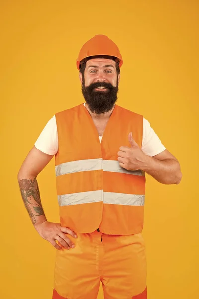 Bra jobbat. Säkerhetsdräkter för byggindustrin. Skägg brutal hipster säkerhetsingenjör. Man ingenjör skyddande uniform orange bakgrund. Tekniskt karriärkoncept. Arkitekt byggmästare — Stockfoto