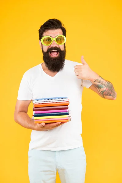 Mi piace la scuola. Happy hipster show pollice in alto. L'uomo barbuto tiene libri scolastici sfondo giallo. Torniamo a scuola. Lezione di inglese. Insegnamento privato. Istruzione e studio. Orario scolastico — Foto Stock