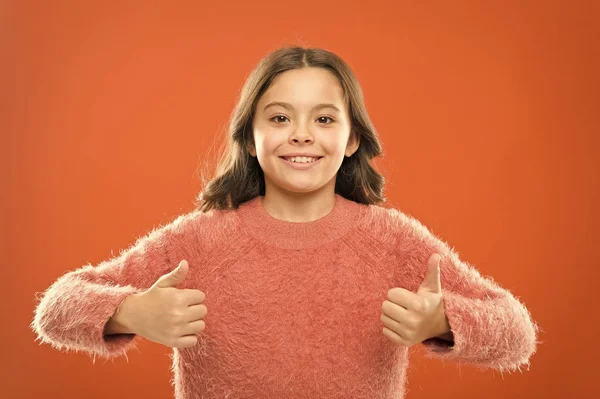 Dia internacional das crianças. Uma menina bem-sucedida a sorrir. camisola de outono pequena criança. se sentir confortável de forma casual. criança alegre segurar o polegar para cima. infância despreocupada. seu sorriso saudável — Fotografia de Stock