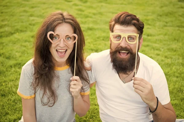 História de amor. Casal relaxante gramado verde. Homem barbudo hipster e mulher bonita apaixonada. Férias. Casal emocional irradiando felicidade. Felizes juntos. Casal no amor alegre jovens adereços cabine — Fotografia de Stock