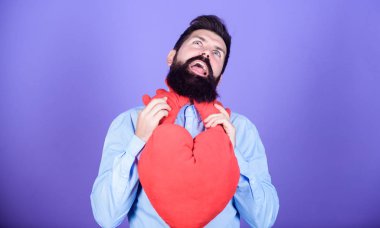 Aşka boğulmuş. Sakallı adam büyük kırmızı bir kalp tutuyor. Kalp krizi ve kalp ağrısı. Sevgililer Günü erkeği 14 Şubat 'ta aşkını ifade ediyor. Aşk hastalığı ve kalp sorunları