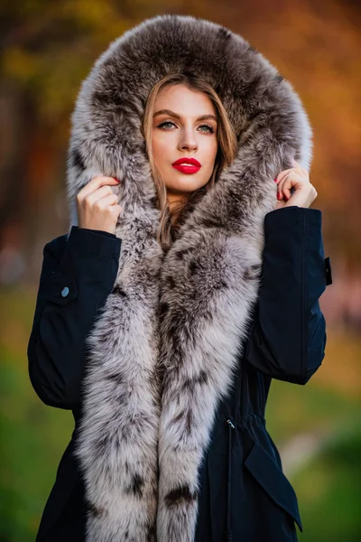 Trendy winterse look. Geen compromis over Comfort. Door de mens gemaakt bont is vatbaar voor vergieten. nep bont van een gerenommeerd merk. elegante meidenwandeling in het herfstpark. schoonheid en mode. vrouw draagt bontjas — Stockfoto