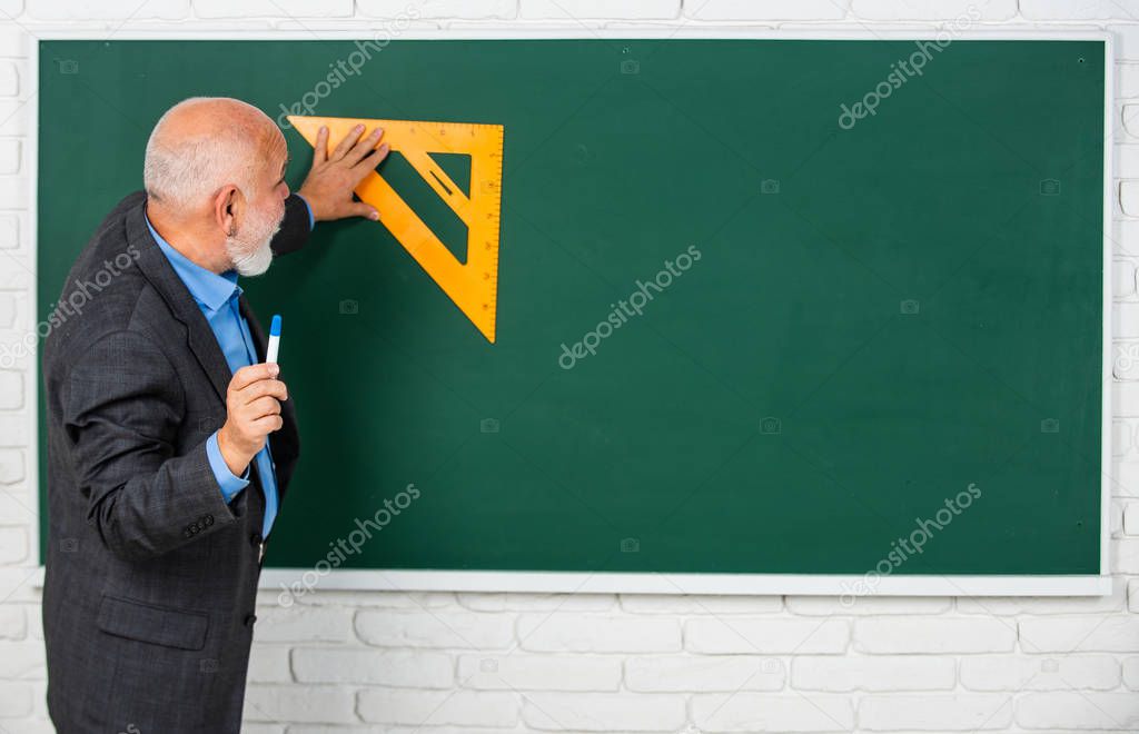mathematics and people concept. Mathematics at board. favorite subject. senior man teacher use math triangle tool. bearded tutor man at blackboard. back to school. copy space