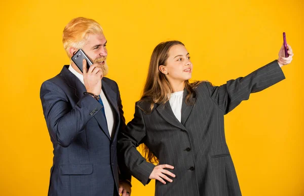 making selfie. entrepreneurship. business discussion. businessman speak on phone with small girl. bearded dad dyed hair. kid oversized jacket. Business people using devices