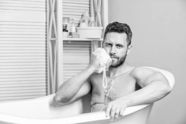 Bain régulier ont une humeur plus effet que l'exercice physique. Homme attrayant avec éponge prendre bain. L'hygiène personnelle. Prenez soin de l'hygiène. Le toilettage personnel nettoie les parties du corps. Concept d'hygiène — Photo