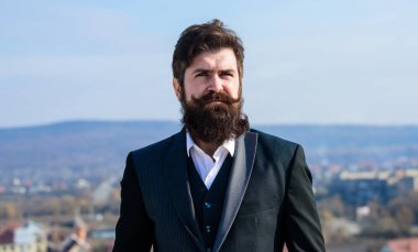 Şık bir görünüme yatırım yap. Hızlı sakal bırak. Sakallı hippi adam resmi takım elbise giyer mavi gökyüzü arka planı. Klasik tarz uzun sakal. Sakal ve bıyık bakımı. Sakal modası eğilimi